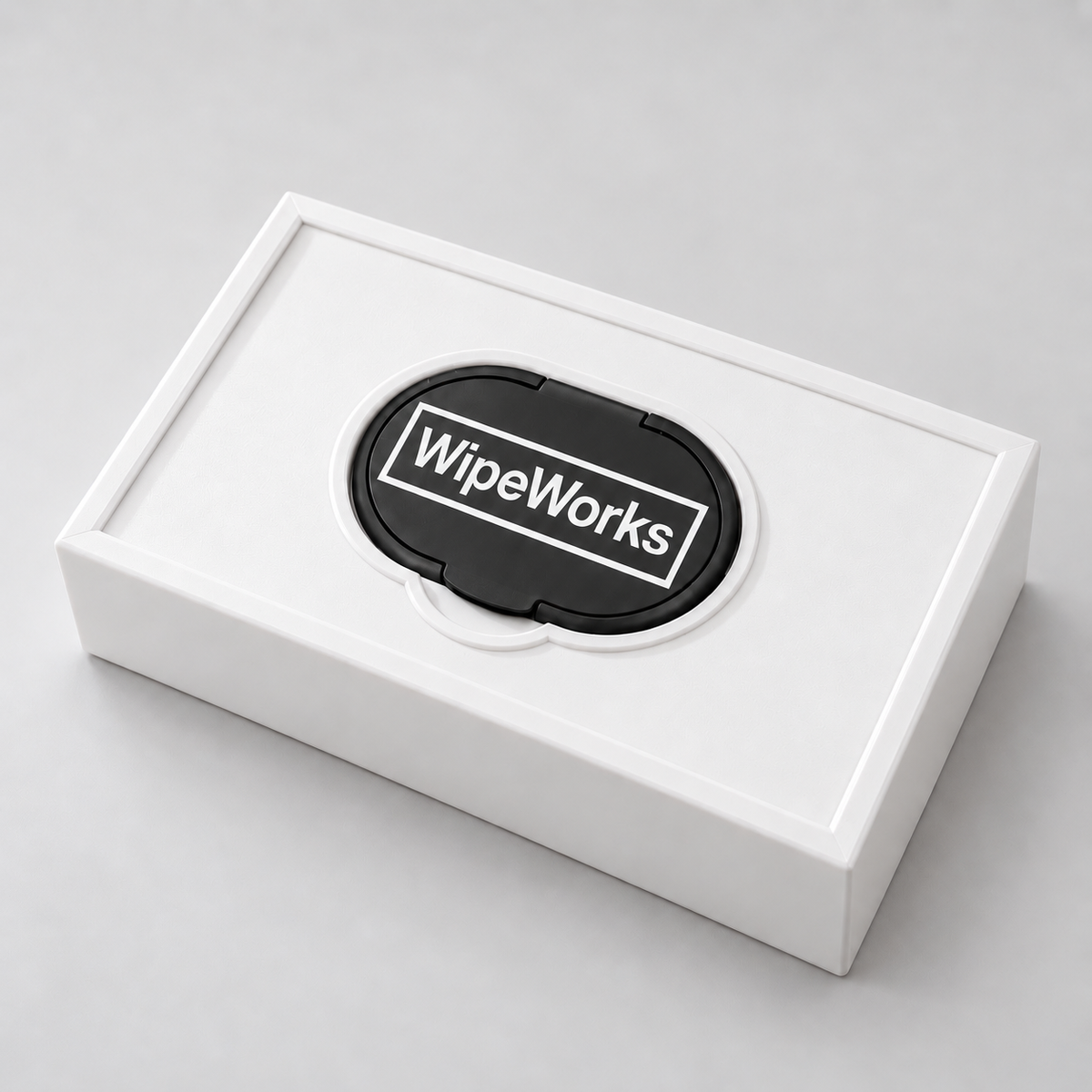 White WipeWorks Lil’ Dudes baby wipe dispenser lying face up with a black pack lid and black lid rim on a neutral studio background.