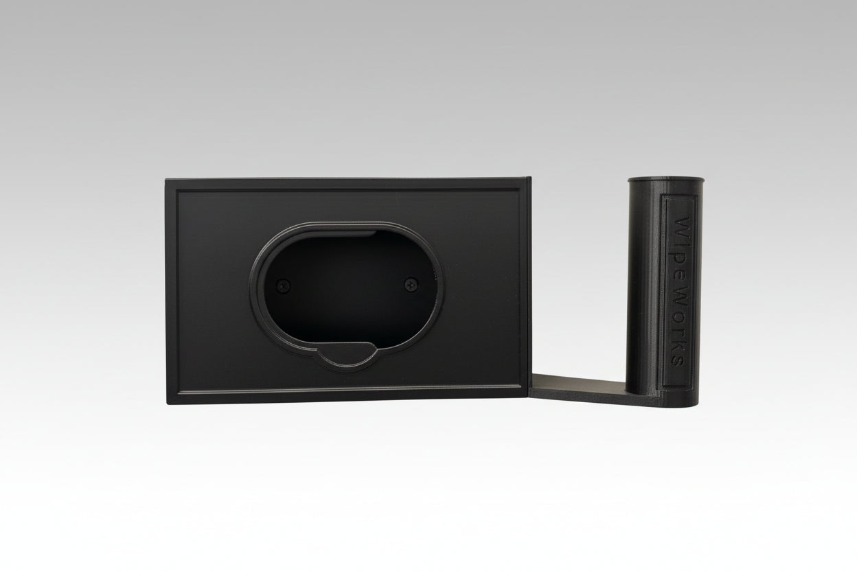 Black wall-mounted WipeWorks bathroom dispenser for flushable wipes and toilet paper without toilet paper or wipes.