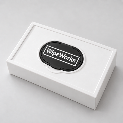 White WipeWorks Lil’ Dudes baby wipe dispenser lying face up with a black pack lid and black lid rim on a neutral studio background.